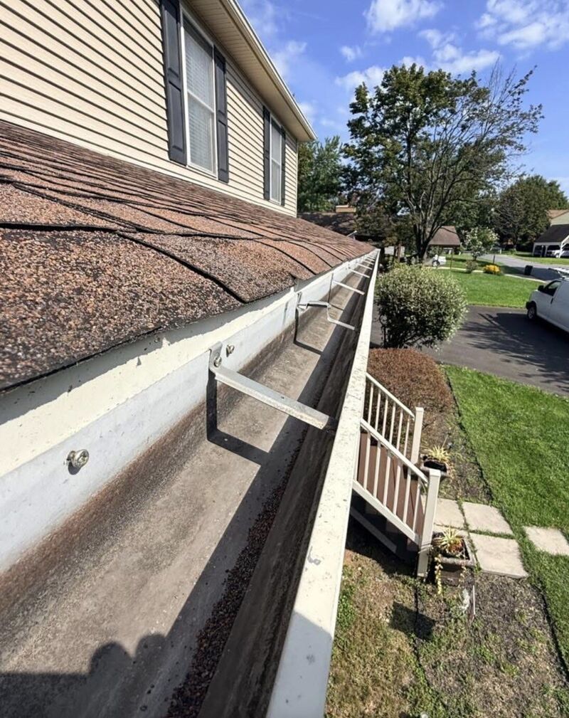 Gutter trough filled with shingle granules and grit before hand cleaning