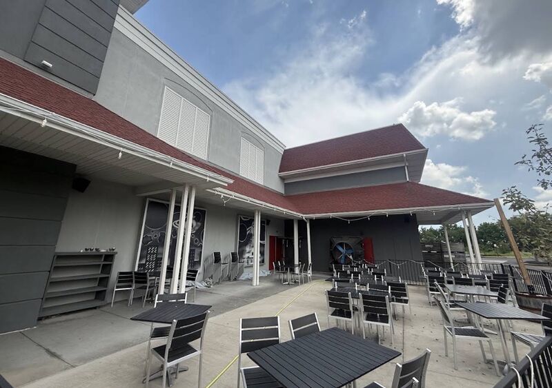 Restaurant outdoor patio with tables and chairs and a cleaned concrete surface